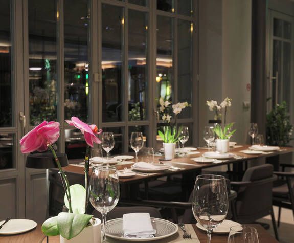 Table setting with pink orchid and glass windows at Clochard restaurant in Excelsior Hotel