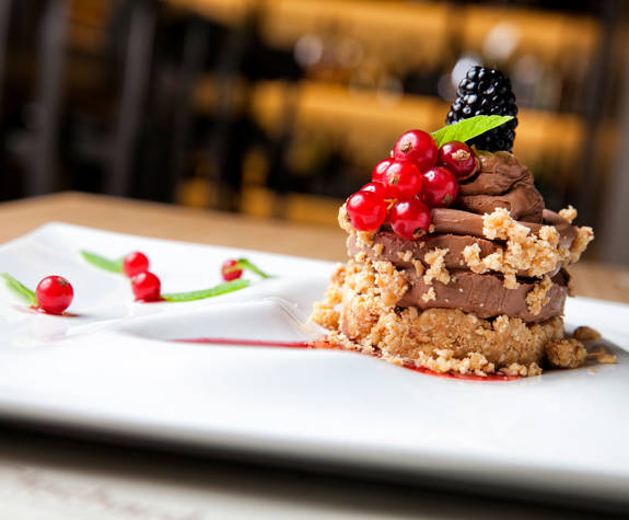 Chocolate dessert with berries and crumble served at Clochard restaurant in Excelsior Hotel